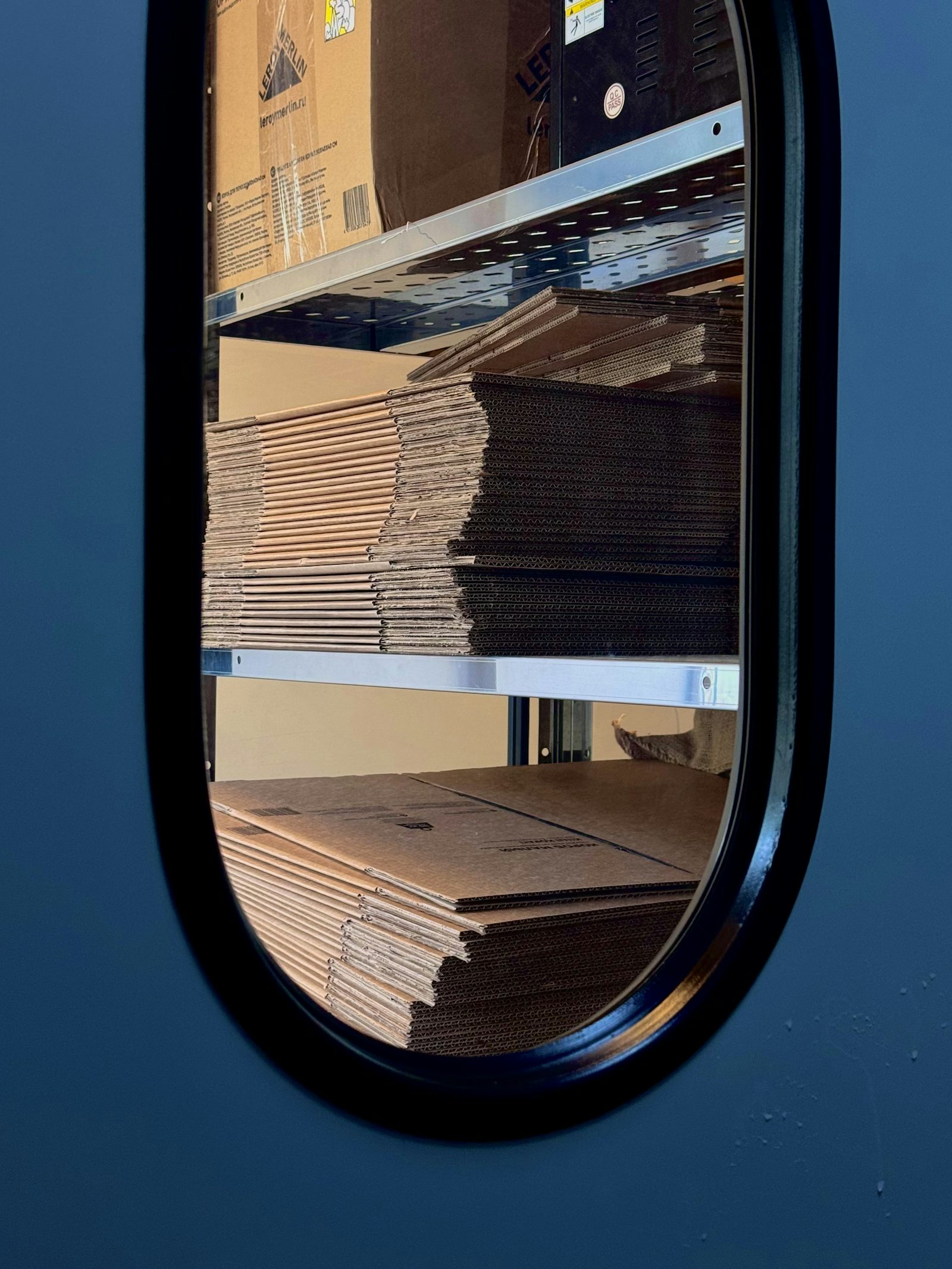 A stack of flat cartons on a shelf